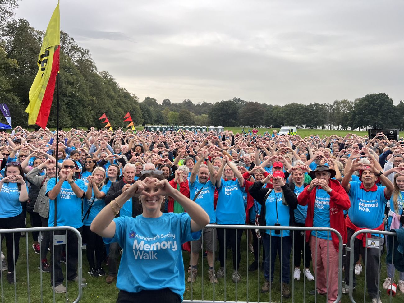 Memory Walk participants making heart shapes at a charity event
