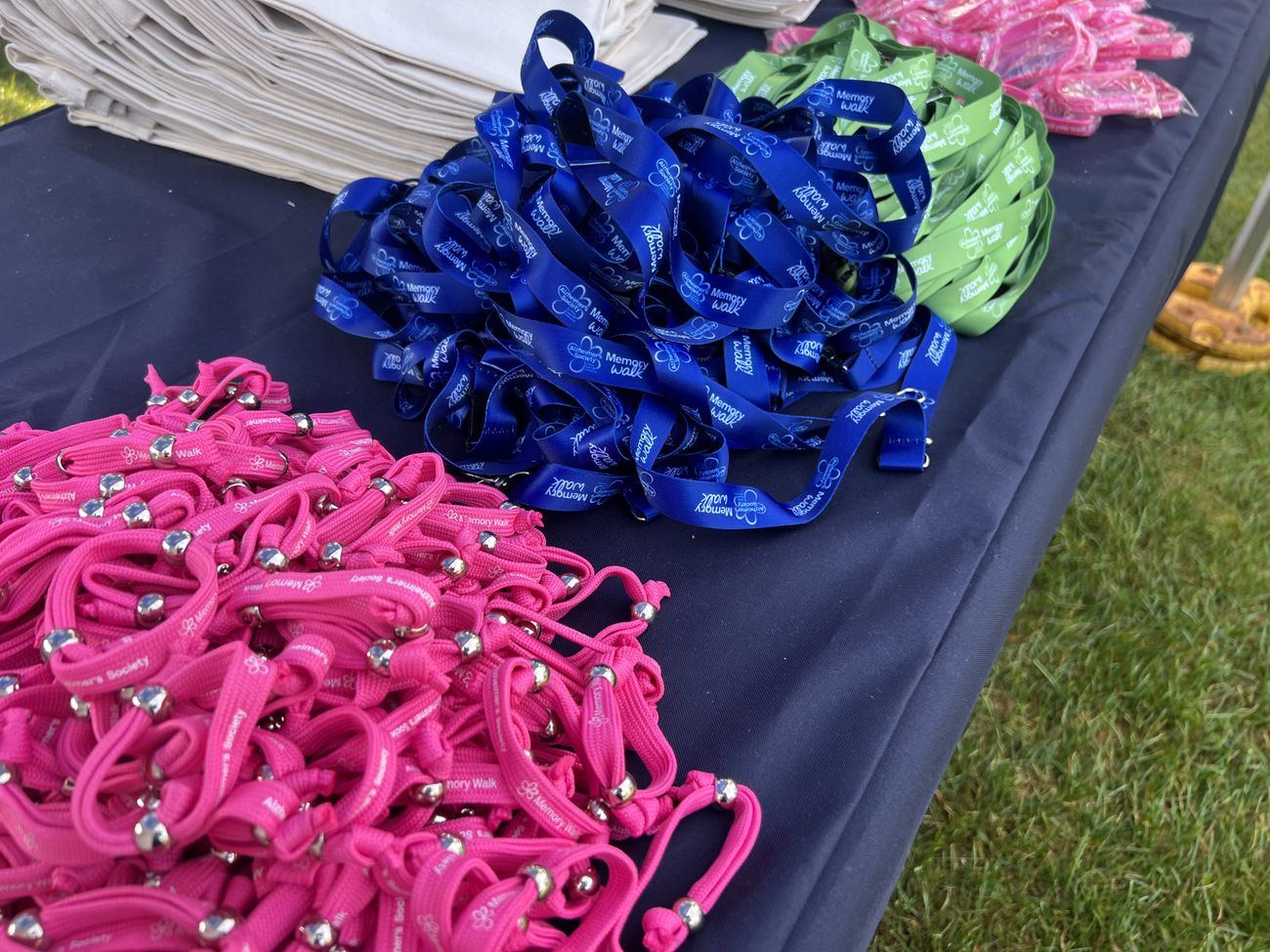 Stacks of pink, blue and green Memory Walk medals on a finish-line table