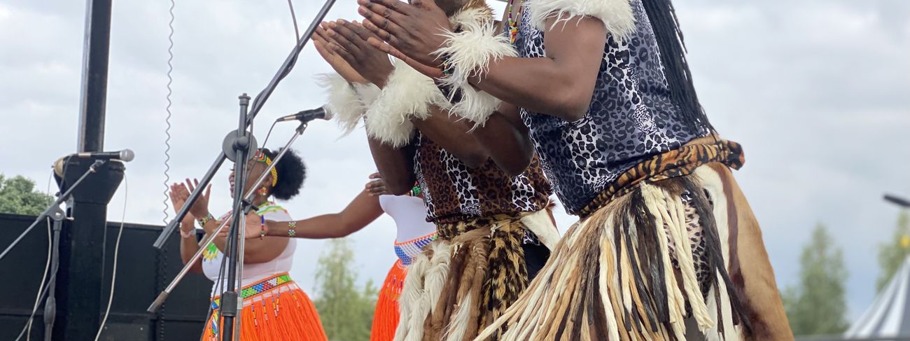 Performers on stage at an outdoor festival