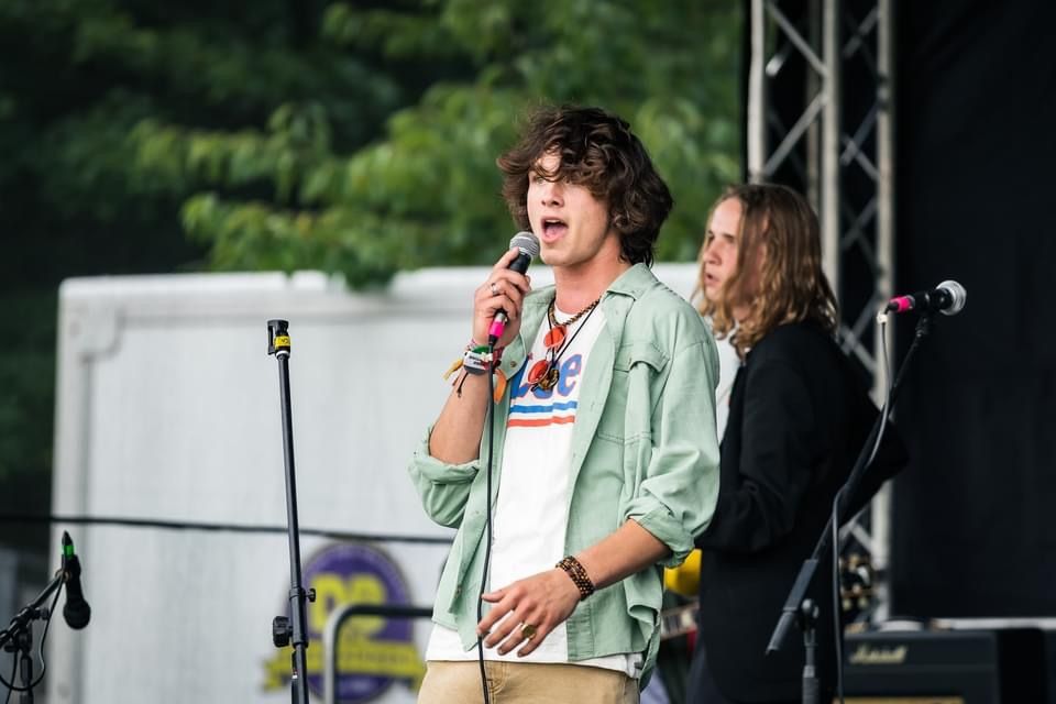 Singer performing on stage at a fundraising music event